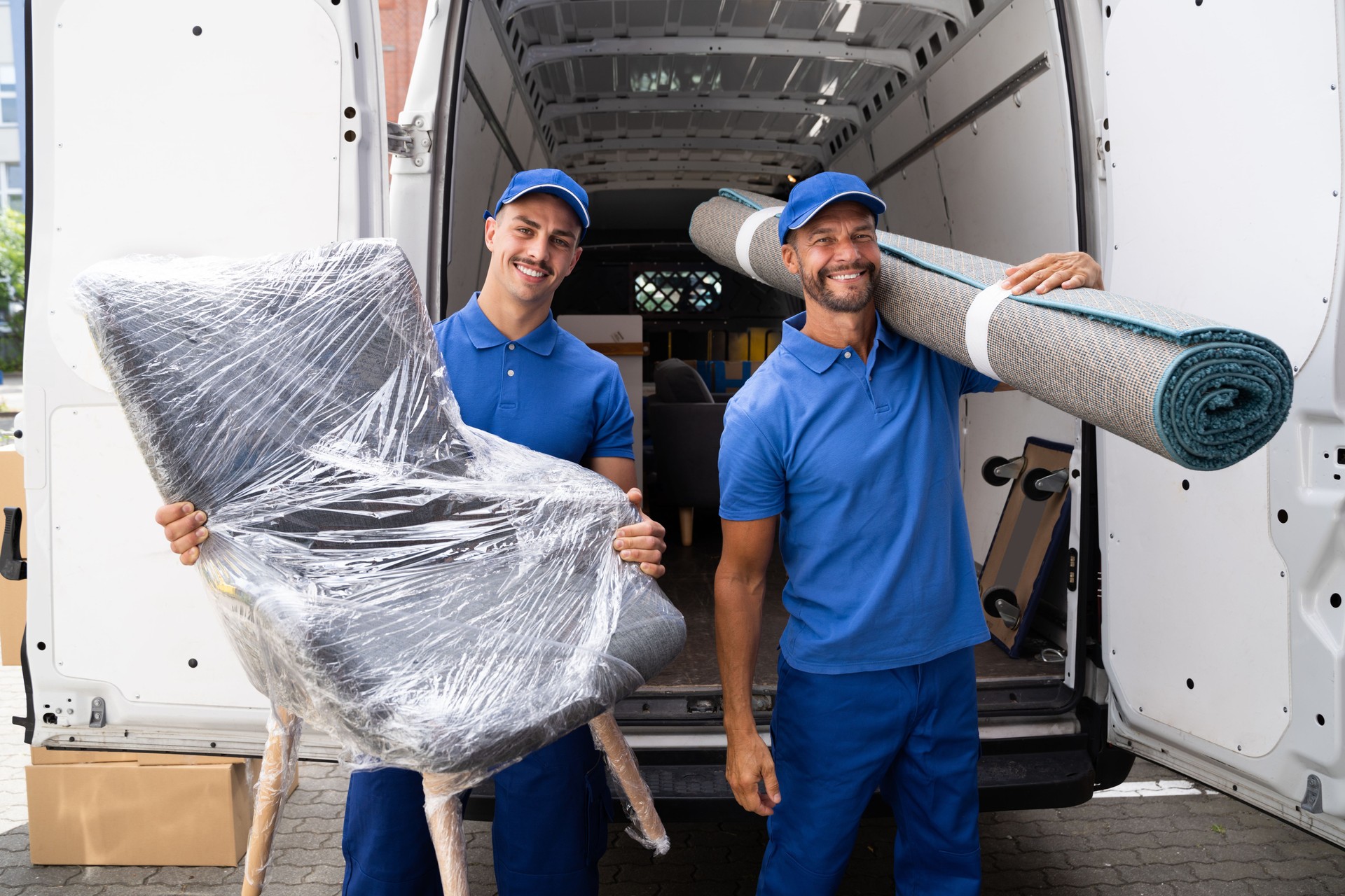 Movers Doing Furniture And Carpet Removal From Truck